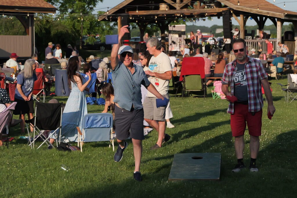 Two men playing corn hole on the grass in front of The Hangtime at Treleaven Wines